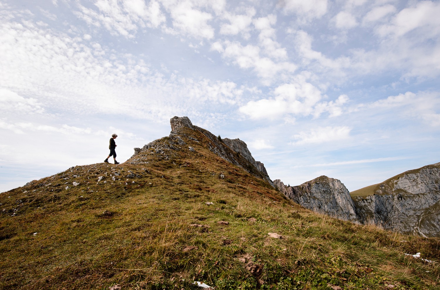 Le col de la Scheidegg: la silhouette d’une randonneuse se découpe dans le paysage. Photos: Susanne Keller