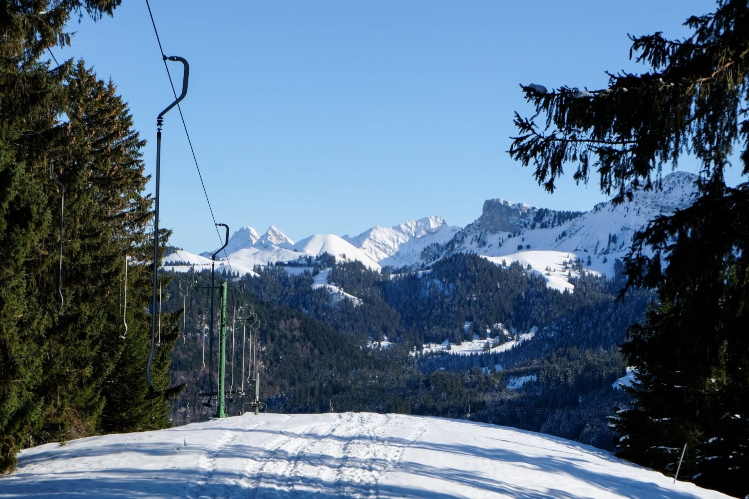 Abstieg entlang des Skilifts mit Sicht auf die Freiburger Berge.